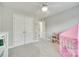 Neutral toned bedroom with white closet and shelving, plush carpeting, and a pink play tent at 9217 Tenby Ln, Matthews, NC 28104