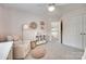 Comfortable bedroom with seating, shelving, and plush, neutral toned carpeting at 9217 Tenby Ln, Matthews, NC 28104