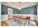 Elegant dining room with a modern chandelier, wainscoting, and a large dining table at 9217 Tenby Ln, Matthews, NC 28104