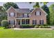 Charming brick two-story home featuring a manicured lawn and traditional architectural details at 9217 Tenby Ln, Matthews, NC 28104