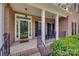 Inviting covered front porch with rocking chairs and brick detailing at 9217 Tenby Ln, Matthews, NC 28104