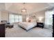 Spacious bedroom featuring tray ceiling, large windows, and neutral-toned decor at 9217 Tenby Ln, Matthews, NC 28104