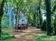 An expansive backyard with a wooden deck is surrounded by a forest of trees at 9907 Furlong Trl, Charlotte, NC 28269