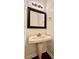 Bathroom with a pedestal sink, framed mirror, and neutral decor at 9907 Furlong Trl, Charlotte, NC 28269