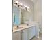 Bright bathroom featuring a double sink vanity with a large mirror and tile flooring at 9907 Furlong Trl, Charlotte, NC 28269