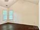 Bright bedroom featuring hard wood floors, two large windows, and neutral paint at 9907 Furlong Trl, Charlotte, NC 28269