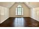 Bright bedroom featuring vaulted ceilings, hardwood floors, and a large arched window at 9907 Furlong Trl, Charlotte, NC 28269