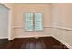 Dining room featuring wood floors and white chair rail with a window at 9907 Furlong Trl, Charlotte, NC 28269