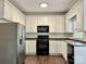 Kitchen features white cabinets, black appliances, and a stainless-steel refrigerator at 9907 Furlong Trl, Charlotte, NC 28269