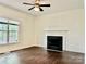 A spacious living room featuring a fireplace, ceiling fan, window, and hardwood floors at 9907 Furlong Trl, Charlotte, NC 28269