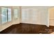 Bright living room features natural light from large windows and dark hardwood floors at 9907 Furlong Trl, Charlotte, NC 28269