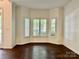 A living room with wood floors featuring a bay window with white wood blinds at 9907 Furlong Trl, Charlotte, NC 28269