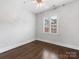 Bright bedroom with hardwood floors, ceiling fan, and a window with custom shutter blinds at 100 N Laurel Ave # 107, Charlotte, NC 28207