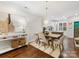 Bright dining room featuring a modern chandelier, seating for four, and view into kitchen at 100 N Laurel Ave # 107, Charlotte, NC 28207