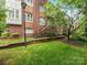 Attractive brick condo building with stairs leading to upper-level units, nestled amongst lush greenery at 100 N Laurel Ave # 107, Charlotte, NC 28207