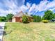 Spacious backyard featuring well-maintained lawn, and a brick garage on a partly cloudy day at 1021 Mallard Landing Dr, Monroe, NC 28110