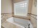 Large white soaking tub with tile surround offers a relaxing spa-like experience at 1021 Mallard Landing Dr, Monroe, NC 28110
