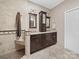 Bathroom features a granite countertop with double sinks, dark wood cabinets, and tiled shower at 1021 Mallard Landing Dr, Monroe, NC 28110
