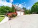 Two-car brick garage with flower beds lining the driveway on a sunny day at 1021 Mallard Landing Dr, Monroe, NC 28110