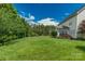 Lush backyard with well-maintained lawn, mature trees, and manicured landscaping surrounding the home at 10418 Goosefoot Nw Ct, Concord, NC 28027