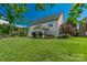 Spacious backyard with vibrant green lawn and a charming home featuring a sunroom and mature landscaping at 10418 Goosefoot Nw Ct, Concord, NC 28027