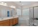 Bathroom featuring a corner tub, shower stall with glass doors, and a double vanity sink at 10418 Goosefoot Nw Ct, Concord, NC 28027