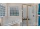 Bathroom featuring a shower stall with glass doors, corner tub, and window providing natural light at 10418 Goosefoot Nw Ct, Concord, NC 28027