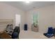 Bright bedroom with neutral walls, featuring a window providing natural light and a comfortable chair at 10418 Goosefoot Nw Ct, Concord, NC 28027