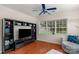 Bedroom with hardwood floors, a ceiling fan and a built in bookshelf and entertainment center at 10418 Goosefoot Nw Ct, Concord, NC 28027