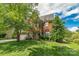 Two-story brick home showcasing a well-manicured lawn, mature trees, and blue shutters at 10418 Goosefoot Nw Ct, Concord, NC 28027