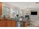 Open kitchen with stainless steel appliances and a view of the living room with a fireplace at 10418 Goosefoot Nw Ct, Concord, NC 28027
