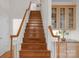 Staircase with wooden steps and white railing leading to the upper level, adjacent to built in cabinetry at 10418 Goosefoot Nw Ct, Concord, NC 28027