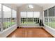 Bright sun room with hardwood floors and multiple windows overlooking the well-maintained yard at 10418 Goosefoot Nw Ct, Concord, NC 28027