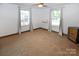 Cozy bedroom with two bright windows, carpet, a ceiling fan, and neutral decor at 1101 Pee Dee Ave, Albemarle, NC 28001