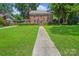 Beautiful two-story brick home with a sprawling front lawn and inviting walkway at 1101 Pee Dee Ave, Albemarle, NC 28001