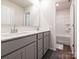 Bathroom featuring double sink vanity, neutral color palette, and a separate shower area at 11019 Daisy Ct, Charlotte, NC 28262
