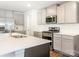 Well-equipped kitchen featuring stainless steel appliances, white subway tile, and streamlined gray cabinets at 11019 Daisy Ct, Charlotte, NC 28262