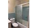 Bathroom with blue tiled walls, a white toilet, and a tub with sliding glass doors at 1120 Mcintyre Rd, Wingate, NC 28174