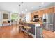 Inviting kitchen with a breakfast bar, stainless steel refrigerator, and hardwood floors at 119 Steinbeck Way # E, Mooresville, NC 28117