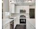 Bright kitchen boasts white cabinets, quartz countertops, stainless appliances and stylish black marble floors at 1423 Ebinport Rd, Rock Hill, SC 29732