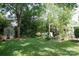 Lush green backyard with mature trees, garden, shed, and patio, offering a serene outdoor retreat at 14406 Gadwall Ct, Charlotte, NC 28273