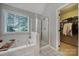 Bright bathroom featuring a soaking tub with a window view and a glass-enclosed shower at 1506 Ivy Bluff Way, Matthews, NC 28105