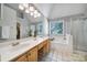 Bathroom with a large mirror, double sinks, soaking tub, and glass-enclosed shower at 1506 Ivy Bluff Way, Matthews, NC 28105