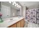 This bathroom features a double sink vanity with a large mirror and floral shower curtain at 1506 Ivy Bluff Way, Matthews, NC 28105