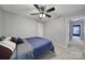 This bedroom has neutral walls, plush carpeting, ceiling fan, and doorway to another room at 1506 Ivy Bluff Way, Matthews, NC 28105