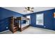 This bedroom has vibrant blue walls and a wooden bunk bed with drawers underneath at 1506 Ivy Bluff Way, Matthews, NC 28105