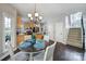 Eat-in kitchen dining area features hardwood floors, a chandelier, and stairs to the second floor at 1506 Ivy Bluff Way, Matthews, NC 28105