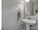 Clean half bathroom features white walls, hardwood floors and pedestal sink at 1506 Ivy Bluff Way, Matthews, NC 28105