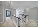 Bright hallway with carpet, a black and white staircase railing, and access to other rooms at 1506 Ivy Bluff Way, Matthews, NC 28105
