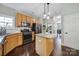 Bright open concept kitchen features wood cabinets, granite countertops, a center island, and stainless appliances at 1506 Ivy Bluff Way, Matthews, NC 28105